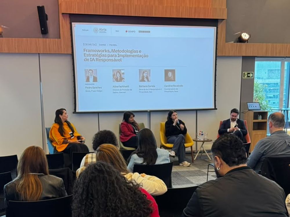 Painel de frameworks e metodologias para implementação de IA responsável, com as quatro pessoas no palco