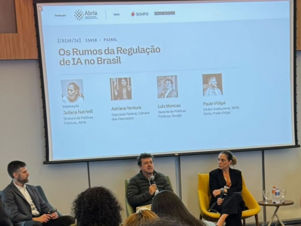 Painel Os Rumos da Regulação de IA no Brasil, com Luiz Moncau ao microfone