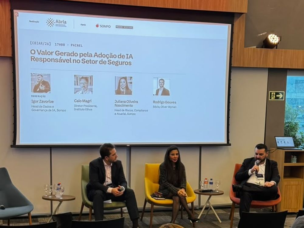Painel sobre o valor gerado pela adoção de IA responsável no setor de seguros, com três pessoas no palco